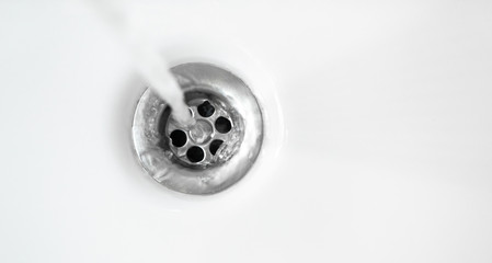 Wall Mural - Water in white ceramic sink drains down, close up