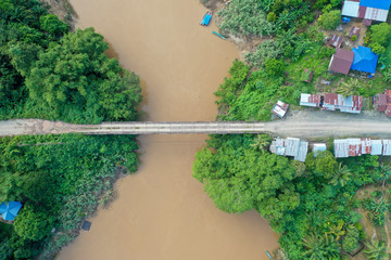 Aerial view of the wild river with the old wooden bridge connecting between two mainland in Kampung Imbak, Tongod, Sabah, Malaysia, Borneo.