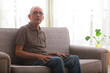 © IndiaPix - Portraits of a senior man sitting on couch at home.