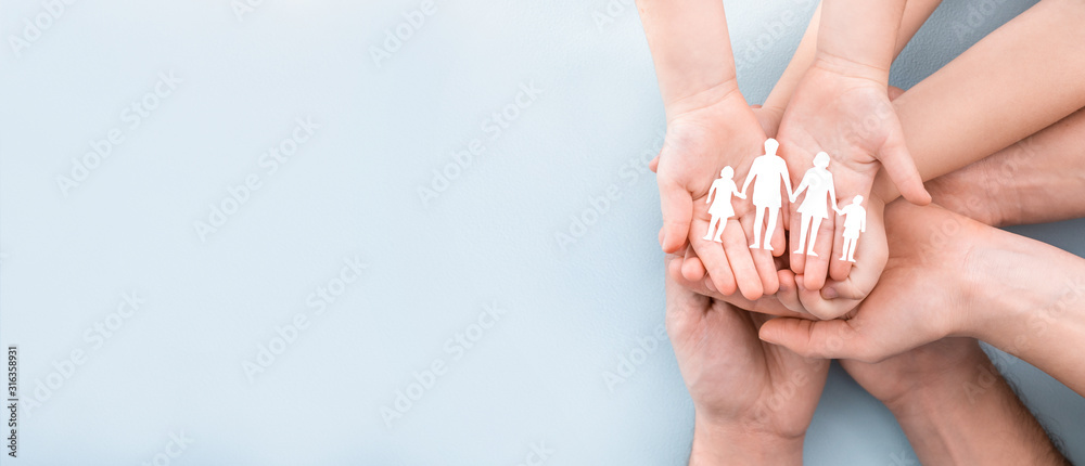 Family care concept. Hands with paper silhouette on table. - obrazy, fototapety, plakaty 