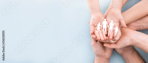Cuadros en Lienzo Family care concept. Hands with paper silhouette on table.
