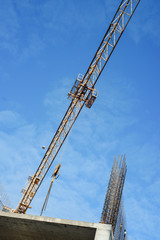  tower cranes against the sky. Yellow construction cranes on a background of blue sky. 