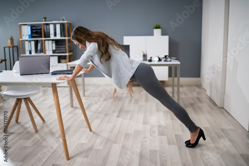 Fotomural Businesswoman Doing Push Up On Office Desk