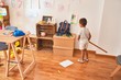 © Krakenimages.com - Beautiful african american toddler playing with horse toy with stick around lots of toys at kindergarten
