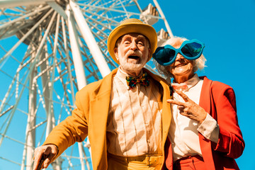 smiling old man and woman in funny clothes having great time