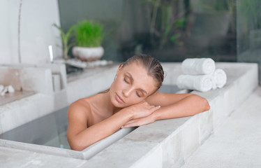 Sticker - Young girl enjoys spa treatments in the bathroom with flowers.