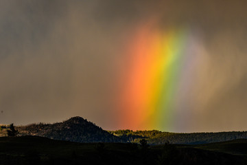 Wall Mural - Wide Rainbow Glows Through Thick Storm Cloud