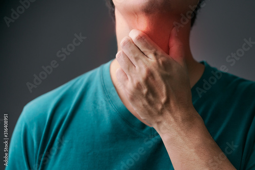 Fotomural Unhappy asian man using his hand touching on his neck Suffering From Gland Inflammation