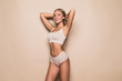 Leinwanddruck Bild - Young woman in underwear on beige background. Fitness, diet, skin and body care