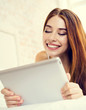© vgstudio - Cheerful smiling brunette girl using tablet computer, at home