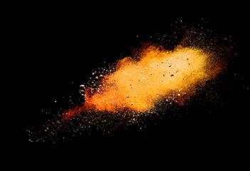 Wall Mural - abstract orange powder explosion isolated on black background.