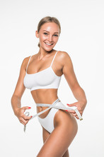 Young Woman Measuring Her Body With A Tape And Looking In Camera . Healthy Lifestyles Concept