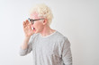© Krakenimages.com - Young albino blond man wearing striped t-shirt and glasses over isolated white background shouting and screaming loud to side with hand on mouth. Communication concept.