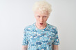 © Krakenimages.com - Young albino blond man wearing casual t-shirt standing over isolated white background afraid and shocked with surprise expression, fear and excited face.