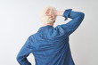 © Krakenimages.com - Young albino blond man wearing denim shirt and glasses over isolated white background Backwards thinking about doubt with hand on head