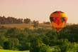 A hot air balloon floats above an Iowa rural landscape.