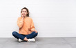© luismolinero - Young woman with curly hair sitting on the floor nervous and scared