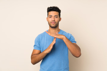 Poster - Young handsome man over isolated background making time out gesture