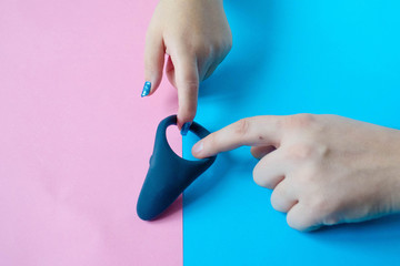 Wall Mural - Sex toy. White Cock ring and hands on a color background. Useful for adult