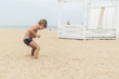 © Konstiantyn Zapylaie - A little boy is jumping in the sand on the beach. Active recreation of the child on the coast of the sea, ocean.