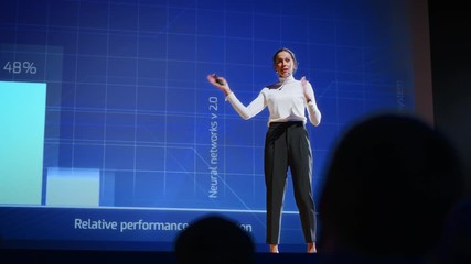 Aufkleber - On Stage, Successful Female Speaker Presents Technological Product, Uses Remote Control for Presentation, Showing Infographics, Statistics Animation on Screen. Live Event / Device Release. Slow Motion