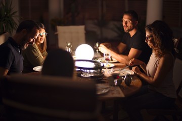 Beautiful family on dinner talking and smiling at terrace