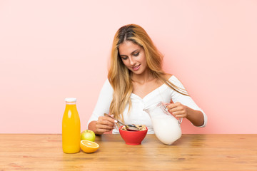 Young blonde woman having breakfast milk