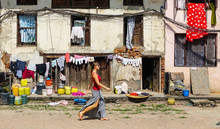 Woman Walks Past An Old Deteriorating House In Residential Part Of Kathmandu.
