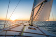 © AlexanderNikiforov - Sailing yacht navigationg to the sun rising on the horizon.. Mediterranean sea, Italy.