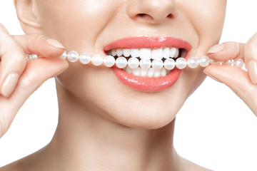 Beautiful female teeth smile and pearl necklace, Dental Health Concept Teeth whitening. Dental clinic patient. Image symbolizes oral care dentistry, stomatology. Isolate en white backround.