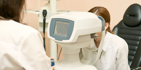 Wall Mural - ophthalmologist doctor in exam optician laboratory with female patient. Eye care medical diagnostic. Eyelid treatment