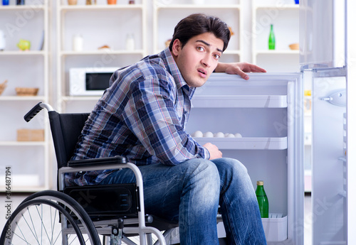 Fotomural Young disabled injured man opening the fridge door