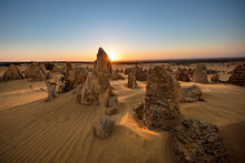 Sun Setting Behind The Limestone Stacks In The Pinnacles Desert In The Nambung National Park Located North Of Perth In Western Australia
