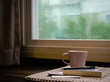 a cup coffee and book on rainy day window background