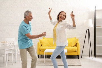 Poster - Happy senior couple dancing in kitchen at home