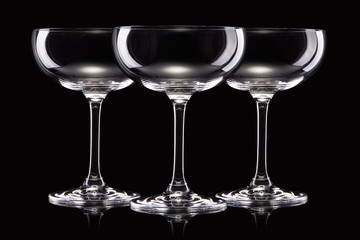 Wall Mural - Set of empty luxury champagne glasses in a row isolated on a black background