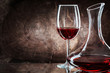 very close up decanter and wineglass with red wine on vintage wooden background