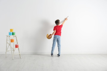 Sticker - Little child painting on blank white wall indoors