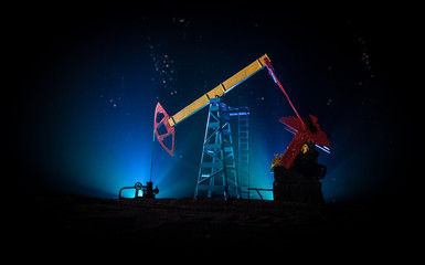 Artwork decoration. Oil pump and oil rig energy industrial machines for petroleum at night with fog and backlight. Oil refining factory. Energy industrial concept. Selective focus