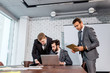 © alfa27 - leadership and business concept. business team in modern office sit having active discussion of business ideas together, wearing tuxedo, formalwear