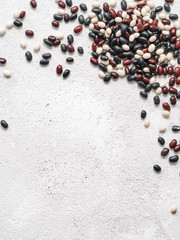 Wall Mural - Top view of raw mixed beans on gray concrete background. Mixed of uncoocked black, red and white beans with copy space. Fodd background. Vegan protein concept.