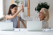 © fizkes - Different generations women colleagues giving high five celebrating common success