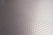 Aluminum surface with many notch spots. Abstract dark gray metallic background or wallpaper. Rows of points go into the distance and form a perspective. Macro