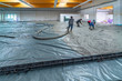 the screed is poured on a construction site inside a large factory building