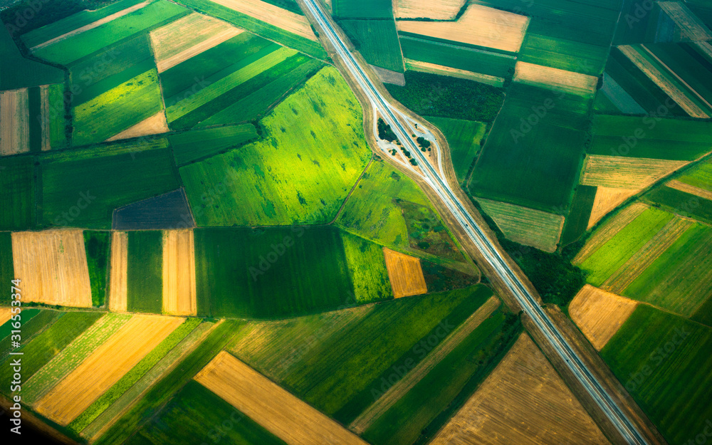 aerial photo from a plane, top view, road through the fields - obrazy, fototapety, plakaty 