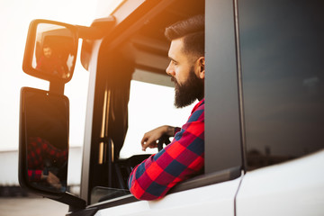 Young handsome bearded man driving his truck.