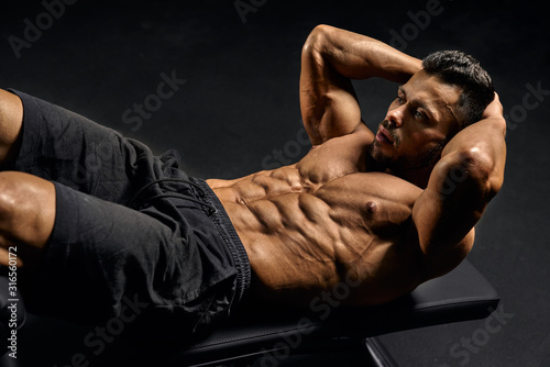 Cuadros en Lienzo Man training abs on mat.