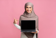Happy Muslim Girl Holding Laptop With Black Screen In Her Hand