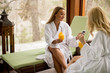 © BGStock72 - Cheerful women in bathrobes drinking juice in spa center