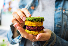 Vegan Chickpea Burgers Cutlets Or Patties. Healthy Vegan Diet Food. Woman Holds In Hand Mixed Vegetables Yellow Pumpkin, Orange Carrot, Green Spinach And Red Beet Chickpea Cutlets.